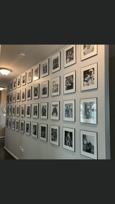 a wall with many pictures on it in an office building's waiting room area