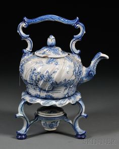 a blue and white tea pot on a stand