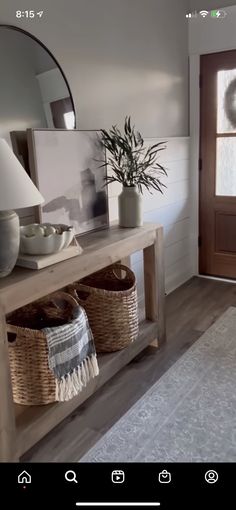 a large mirror sitting above a wooden table next to a door with baskets on it