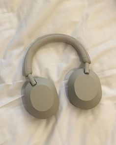 a pair of headphones laying on top of a white sheet