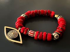 The Red Coral Evil Eye Bracelet displays a unique vibrant style and has immense spiritual and protective power. Featuring red coral stones and a large evil eye charm this bracelet is stylish and powerful to wear during meditation and daily life. The Evil Eye is a prominent symbol in Turkish and many other cultures, and is highly protective. Evil Eye is also called nazar. Evil Eye beads reflect ill intent and jealousy from the 'evil eye' back to the person thinking of it, hence protecting the wea Traditional Red Bracelets For Meditation, Red Spiritual Beaded Bracelets For Meditation, Spiritual Red Coral Beads, Red Coral Beaded Bracelets, Red Bohemian Beaded Bracelets For Meditation, Unique Hand-strung Red Beaded Bracelets, Red Wooden Beads Bracelets As Gift, Red Spiritual Gemstone Beaded Bracelets, Spiritual Red Gemstone Beaded Bracelets