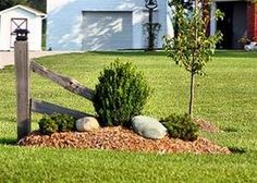 a wooden fence sitting in the middle of a lush green field next to a house