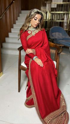 a woman sitting in a chair wearing a red dress