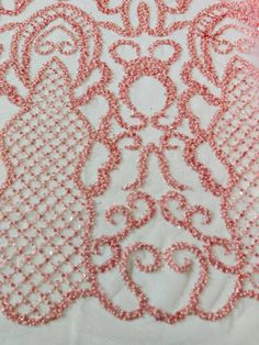 pink beaded lace on white fabric