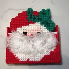 a close up of a santa clause ornament on a white counter top with a red and green background