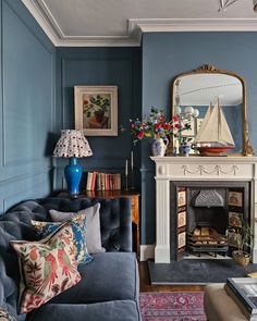 a living room filled with furniture and a fire place in front of a blue wall