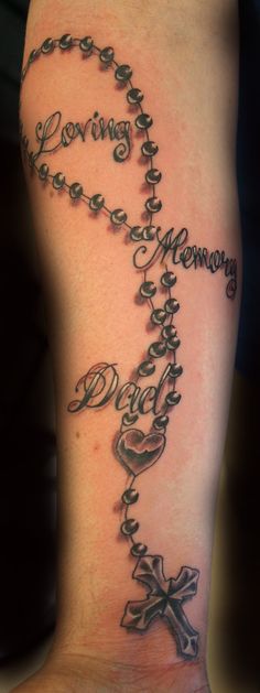 a woman's foot with a cross and rosary tattoo on the side of her leg