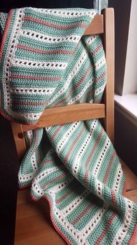 a crocheted blanket sitting on top of a wooden chair