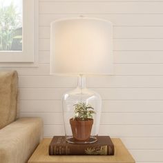 a lamp that is sitting on top of a table next to a book and a couch