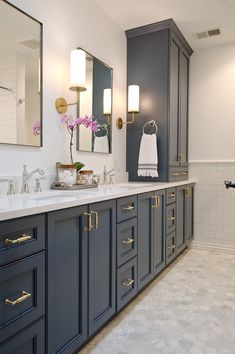 a large bathroom with two sinks and mirrors on the wall, along with blue cabinets