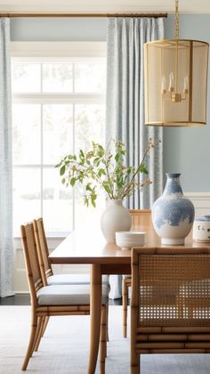 a dining room table with chairs and vases on it