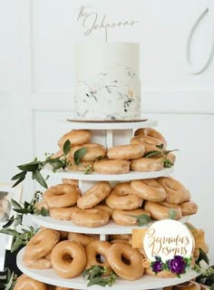 there is a three tiered cake with donuts on it