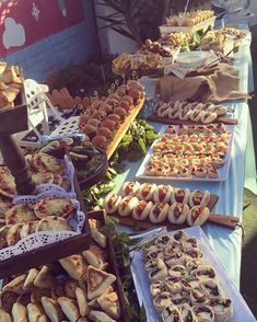 a table filled with lots of different types of food on top of white tables cloths