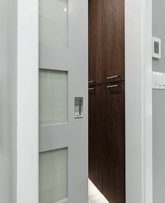 an open door leading to a bathroom with white walls and wood trim on the doors