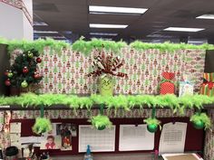 an office cubicle decorated for christmas with green decorations