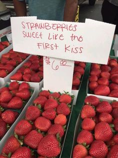 fresh strawberries are for sale at the farmers market, with a sign that says strawberry rings sweet like the first kiss