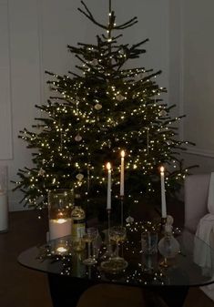 a christmas tree with lit candles in front of it