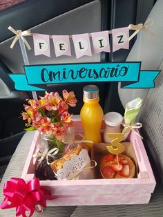 a pink tray filled with food and drinks on top of a car seat next to a sign