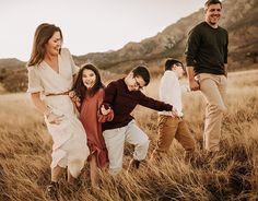 a group of people standing in a field with one holding the other's hand