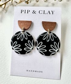 a pair of black and white earrings on top of a card