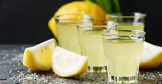 three glasses filled with lemonade sitting on top of a table