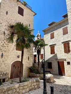 an old stone building with palm trees in the courtyard