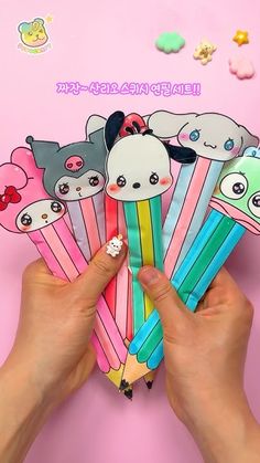 a person holding up some colorful pencils with cute animals on them and the words hello kitty written in japanese