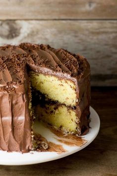 a chocolate cake on a white plate with one slice cut out