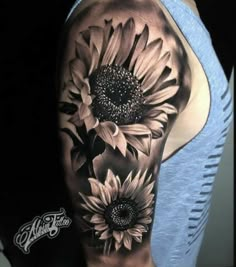 a woman's arm with sunflowers on it and the back of her shoulder