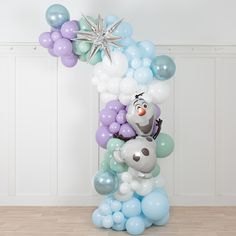 a balloon arch with balloons and a stuffed animal on the top is decorated in pastel colors