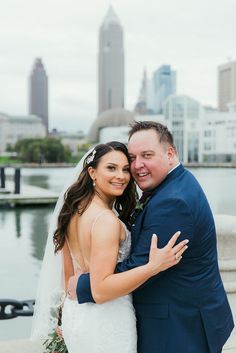 a bride and groom hugging in front of the city skyline