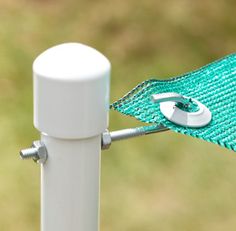 a close up of a white pole with a green cloth on it and a pair of scissors