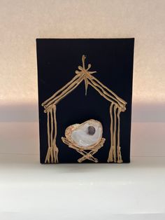 a card with a nativity scene in the shape of a house and a heart