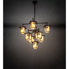 a chandelier hanging from the ceiling in a dark room with light bulbs on it