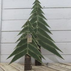 a small green christmas tree sitting on top of a wooden table