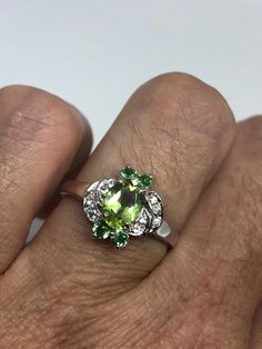 Rich and very bright Peridot, green chrome diopside white white sapphire ring Sterling silver with rhodium finish Size 6.75 can be sized by my jeweler. His service charge is $10-$20 All rings are shipped in a nice gift box. Check out our over a THOUSAND great reviews Engraving is $4 per letter and is not always perfect depending on the piece. It can take a few days if the jeweler is busy. This is payable to Paypal Judithsltd@gmail.com Green Gemstones For Promise Rings, Green Peridot Jewelry With Center Stone, Green Sterling Silver Gemstones With Accent Stones, Sterling Silver Multi-stone Green Emerald Ring, Green Multi-stone Emerald Ring In Sterling Silver, Green Multi-stone Sterling Silver Rings, Gothic Ring, Green Chrome, White Sapphire Ring