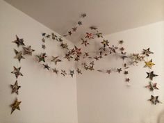 there are many paper stars hanging on the wall in this room, and one is upside down