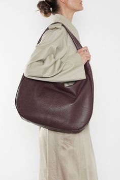 Product Details The Slimline Halo in grain burgundy is a hobo inspired design in a slender, elegant form. Softly slouching, its slim gusset keeps the bag close to the body. A sponged strap constructed with comfort at its core, the minimal style glides between fashion statement, work bag utility and travel bag comfort. With a long zip opening, a laptop fits comfortably inside. Handcrafted exclusively in our Melbourne Atelier from the finest Italian soft pebble grain aniline leather. Proudly manufacturing Australian luxury, designer bags. Delivered in an exclusive A-ESQUE cotton drawstring dust bag for preservation and luxury. Product Features • Material: 100% full-grain aniline leather, Burgundy • Lining: 100% Suede • Height: 33cm | 13'" • Width: 8.5cm | 3.35" • Length: 40cm | 15.75" • Stra Luxury Designer Bags, Large Shoulder Bags, Minimal Style, Work Bag, Minimal Fashion, Designer Bags, Luxury Designer, Travel Bag, Fashion Statement