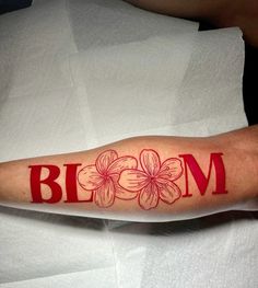 a person with a tattoo on their arm that says bloem in red ink