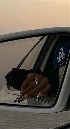 a person's hand is reflected in the side mirror of a car