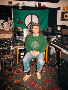 a man sitting in front of a green peace sign