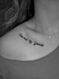 a woman's chest with the words stand by grace tattooed on her left shoulder