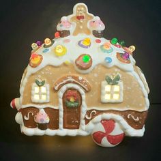 a gingerbread house with candy and candies on the roof is lit up at night