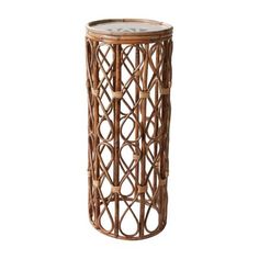 the side table is made out of bamboo and has a glass top with circles on it