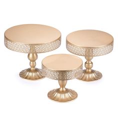 three round gold cake stands on white background