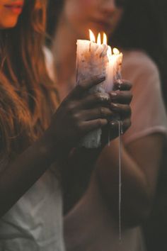 two women holding candles in their hands