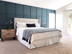 a bedroom with blue walls and white bedding