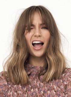 a close up of a person with long hair and a surprised look on their face