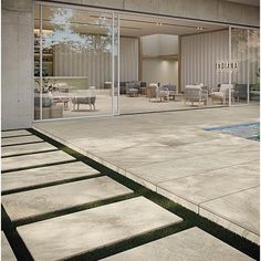 an empty pool in front of a house with sliding glass doors on the outside wall