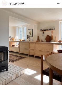 a stove top oven sitting inside of a kitchen next to a wooden table and chairs